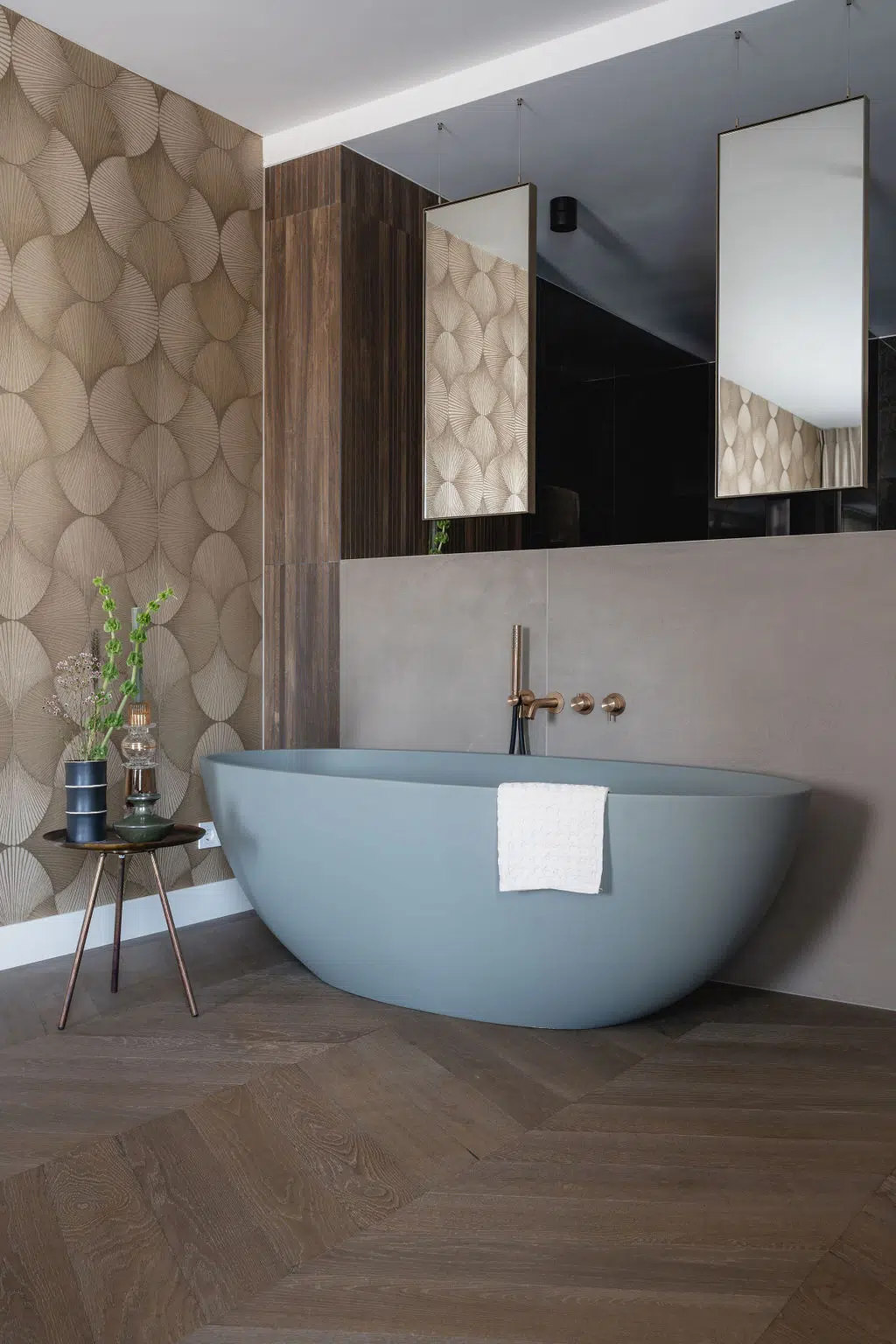 Impressie van een design badkamer in en suite stijl, voorzien van een vrijstaand bad en Gessi kranen in de kleur warm bronze.